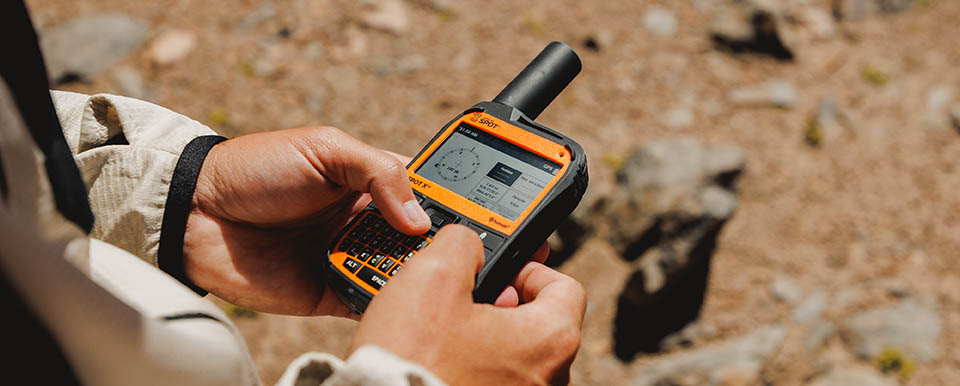 Aventureiro usando o SPOT X em trilha — comunicador satelital bidirecional com teclado físico